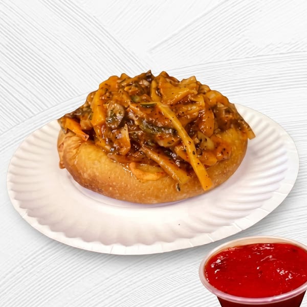 Fried dough topped with a savory mushroom and vegetable sauce, served with a side of red dipping sauce.