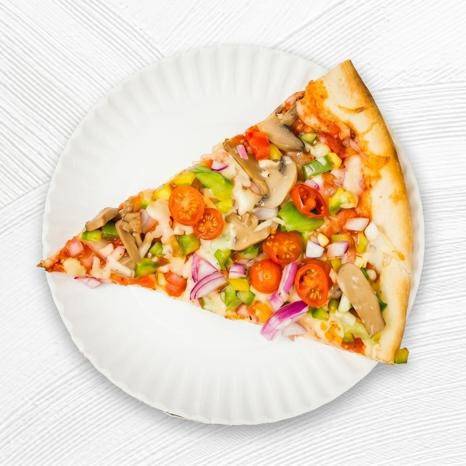 A single slice of vegetarian pizza with mushrooms, peppers, onions, and cherry tomatoes on a white plate.